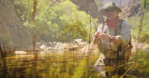 Man fly fishing in tranquil river with clear foreground grass