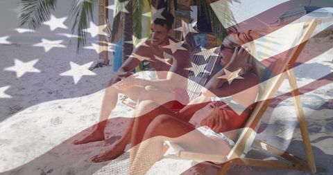 Couple relaxing on tropical beach chairs with american flag overlay, summer vacation
