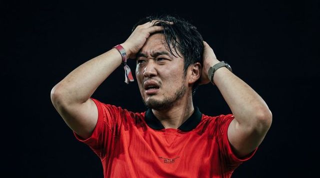 Asian footballer holding head in frustration after missed chance, intense sweaty closeup