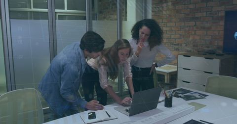 Team Analyzing Data on Laptop in Modern Office