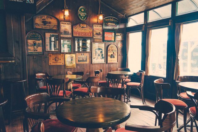 Captures cozy atmosphere of a vintage bar with wooden furniture, wall decor, and warm lighting. Useful for illustrating bar interiors, nostalgic settings, restaurant themes, hospitality industry, vintage decor, and rustic design ideas.