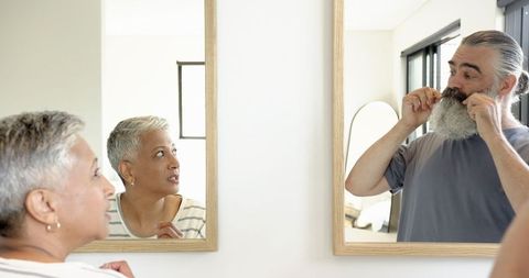 Senior Couple Embracing personal care through reflection and grooming