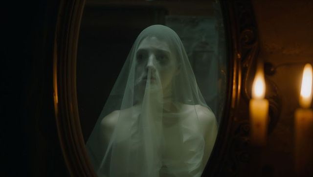 Eerie atmosphere with veiled woman in antique room