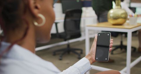 Businesswoman Checking Smartphone in Modern Office Setting - Download Free Stock Images Pikwizard.com