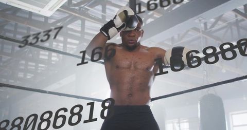 Boxer resting on ropes in industrial gym ring catching breath and focusing on comeback
