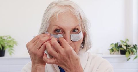 Senior Woman Applying Under-Eye Patches in Home Self-Care Routine