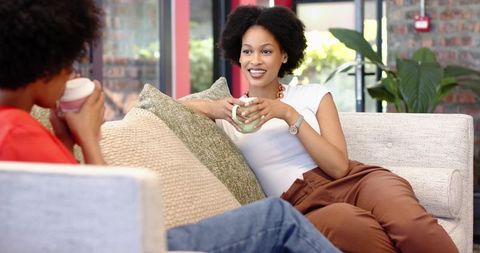 Diverse friends relaxing in modern lounge enjoying coffee