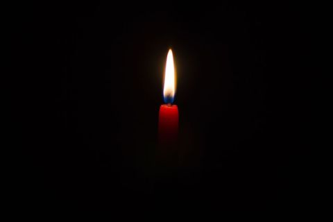 Glowing Red Candle in Dark Background