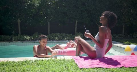 Group of Female Friends Enjoying Relaxation by Backyard Pool