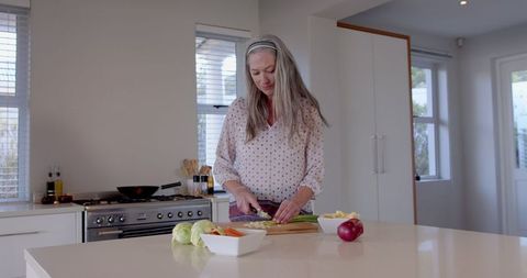 Senior Woman Preparing Fresh Vegetables in Modern Kitchen for Healthy Cooking