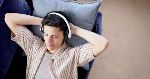 Relaxed Man Listening to Music with Headphones on Comfortable Couch