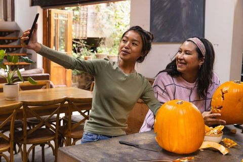 Mother and Daughter Selfie While Carving Pumpkins at Cozy Home