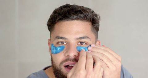 young man applying hydrogel eye patches for refreshed look - Download Free Stock Images Pikwizard.com