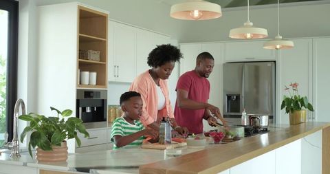 African american family cooking together in modern kitchen preparing healthy meal