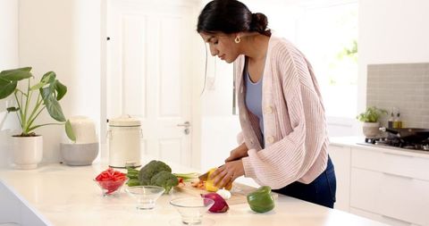 Woman Preparing Vegetables in Modern Kitchen Setting