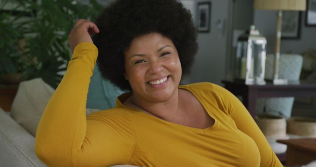 Smiling Woman with Afro Hair Relaxing Indoors in Yellow Top - Download Free Stock Images Pikwizard.com
