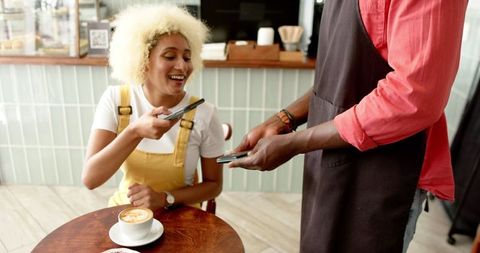 Cashless payment with smartphone in cafe scene