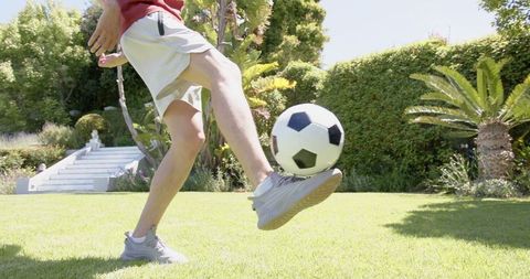 Skillful Soccer Player Practicing Kicks in Sunny Garden