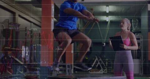 Athlete Performing Plyo Box Jumps While Trainer Tracking Performance With Data Visuals