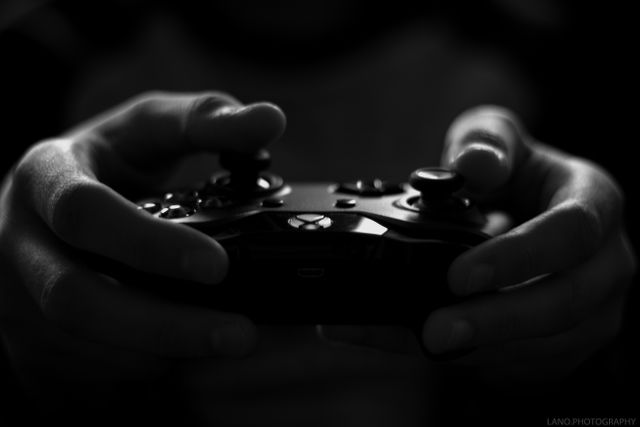 Close-up of Hands Holding Game Controller in Dark Setting - Download Free Stock Photos Pikwizard.com