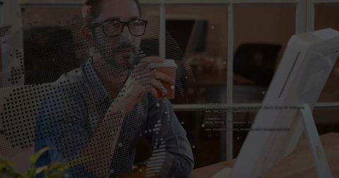 Developer analyzing code while holding mug in modern workspace