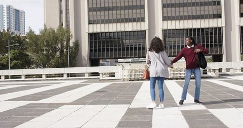 Couple Holding Hands on Tiled Urban Plaza Near Modern Office Building, Casual City Romance