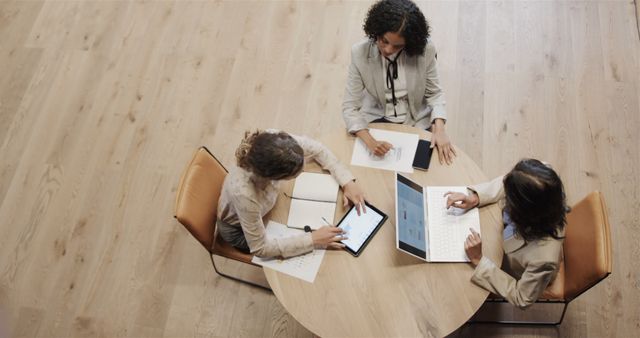 Above view of diverse business team discussing office project at round table - Download Free Stock Images Pikwizard.com