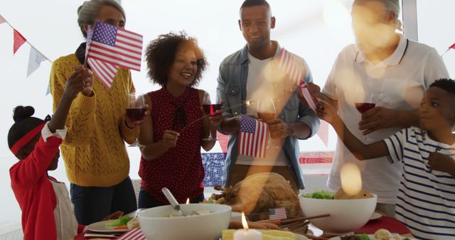 Family members of different generations celebrating Independence Day, holding American flags and enjoying a feast. Ideal for use in content related to national holidays, familial bonding, diversity, and festive gatherings.