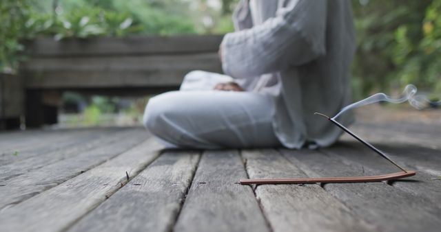 Person Meditating Outdoors with Incense on Wooden Deck - Download Free Stock Images Pikwizard.com