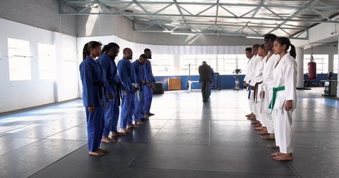 Diverse martial arts class practicing facing drills in dojo