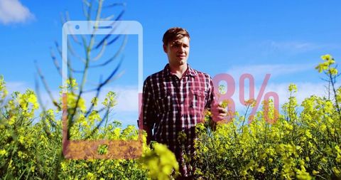 Young man standing in canola field with smartphone overlay and red 28% low battery concept