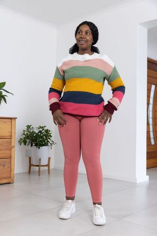 Woman in Colorful Knit Sweater Standing at Home