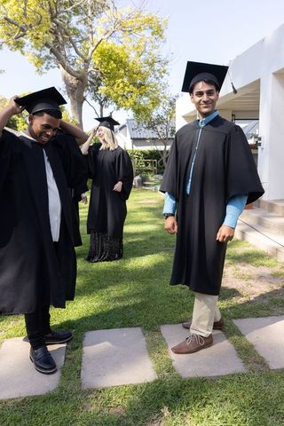 Graduates Celebrating Achievement with Diverse Classmates Outdoors