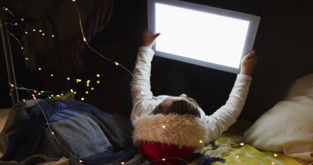 Child Using Tablet in Dark Room with Festive Lights - Download Free Stock Images Pikwizard.com