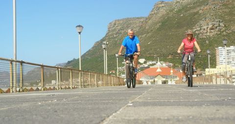 Senior Couple Riding Bicycles on Scenic Promenade