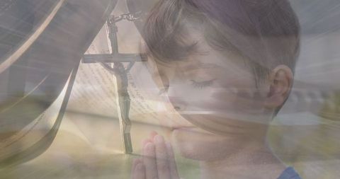 Young Boy Praying with Cross Symbol and Light Reflections