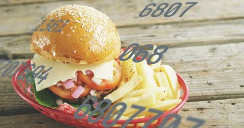 Cheeseburger and fries in red basket on rustic wood table with numeric overlays