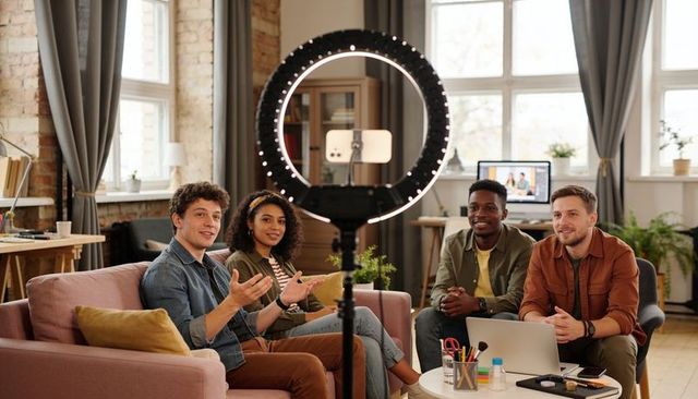 Diverse team recording casual livestream with ring light in modern creative studio