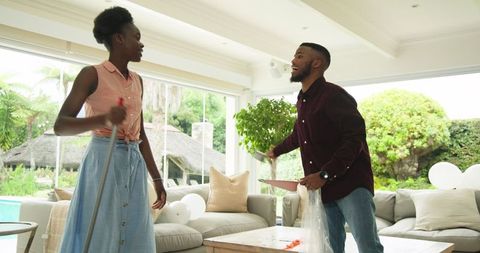 Couple Enjoying Spring Cleaning in Bright Living Room