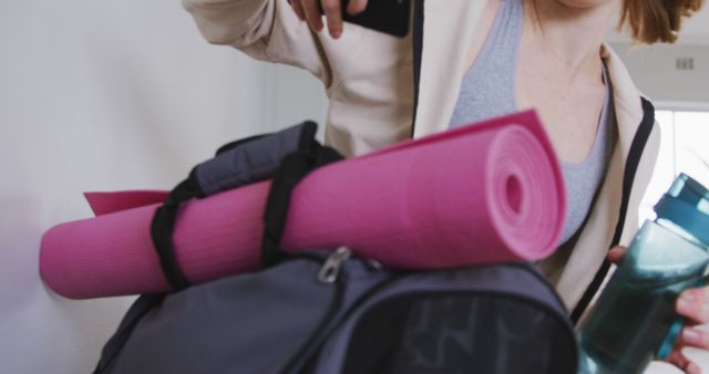 Woman Packing Yoga Mat and Water Bottle into Gym Bag - Download Free Stock Images Pikwizard.com