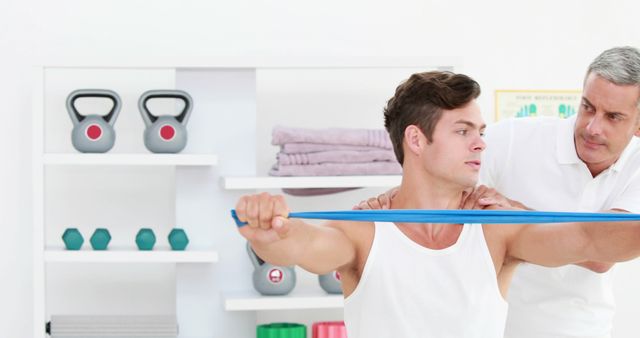 Male Patient Exercising with Resistance Band Under Physical Therapist Supervision - Download Free Stock Images Pikwizard.com