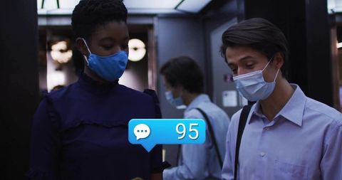 Professionals wearing masks checking chat alert in elevator