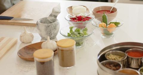 Home kitchen prep with mortar and pestle, fresh chilies, cilantro and spices