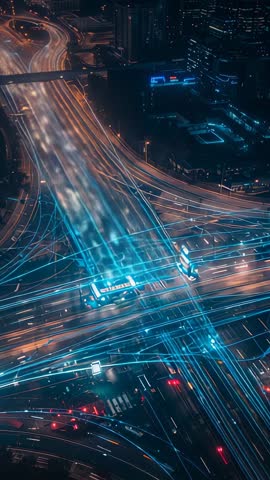 Drone filming neon light trails across highway interchange at night — vertical timelapse