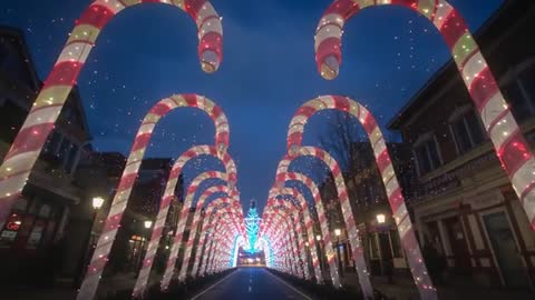 Enchanted Journey Under Illuminated Candy Cane Arches at Dusk