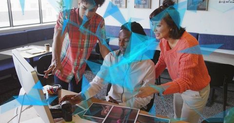 Creative team collaborating on photography prints and dslr workflow in modern office