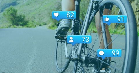 Cyclist pedaling on rural road showing social media notification overlays for engagement