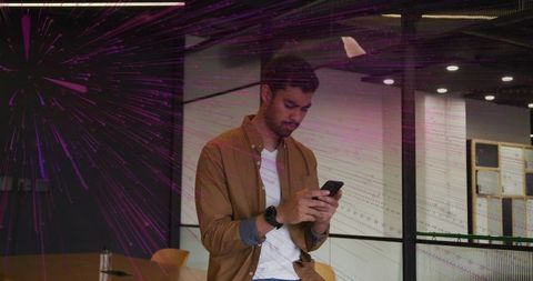 Young Professional Checking Smartphone in Modern Office Setting