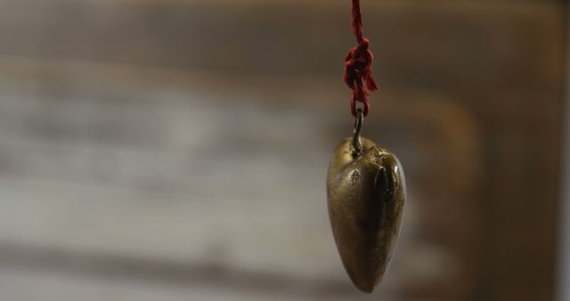 Heart shaped decoration hanging in mid air. Pendant tied to string 4k