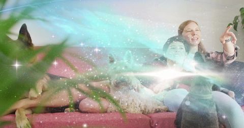 Women relaxing on pink sofa petting dogs, sharing companionship under dreamy aurora glow